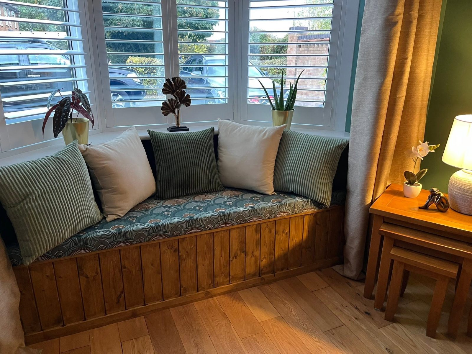 Panelled bay window seat with patterned cushion and pillows