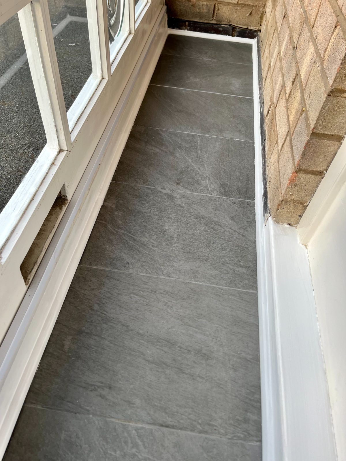 Slate-tiled porch floor laid between painted skirtings