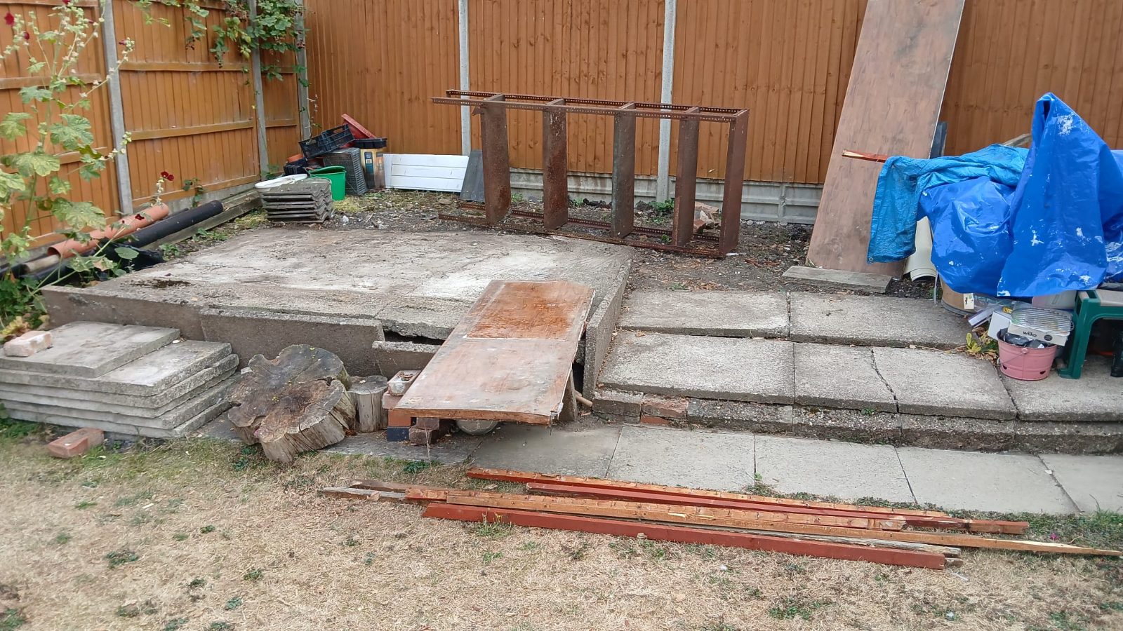 Rubble-strewn back yard with broken concrete steps