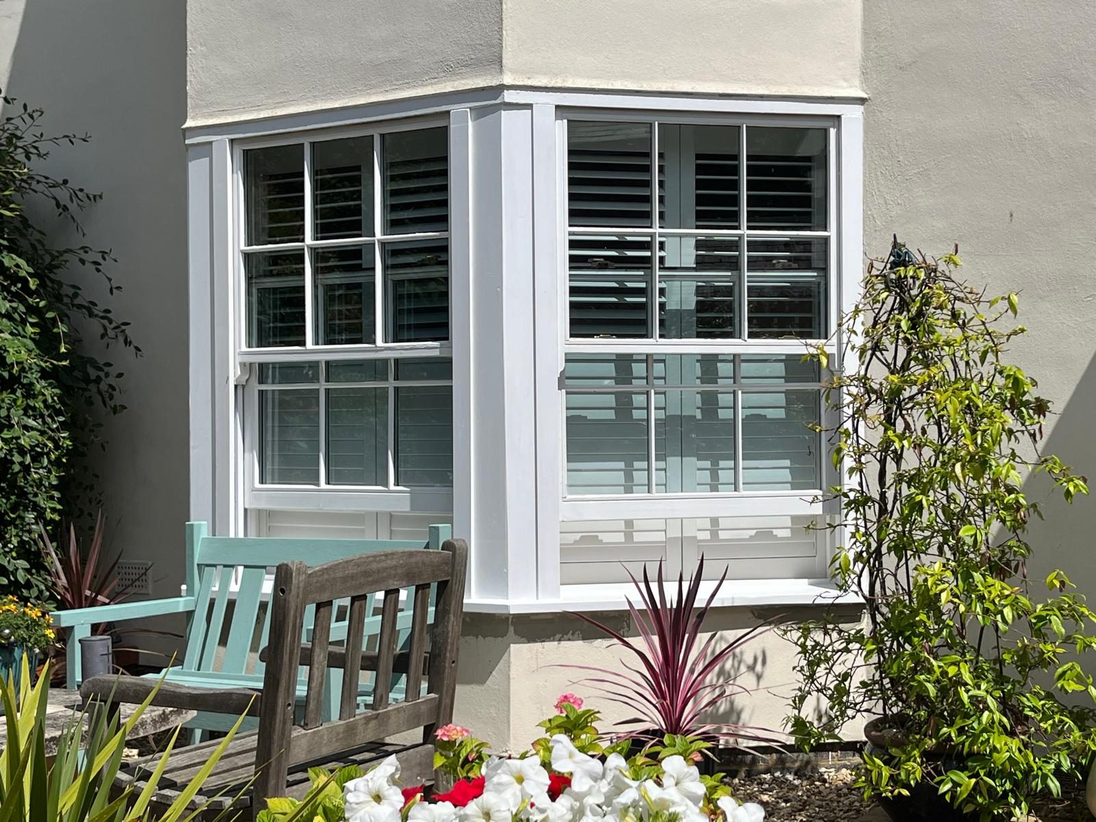 Rebuilt bay window painted white with planting in front