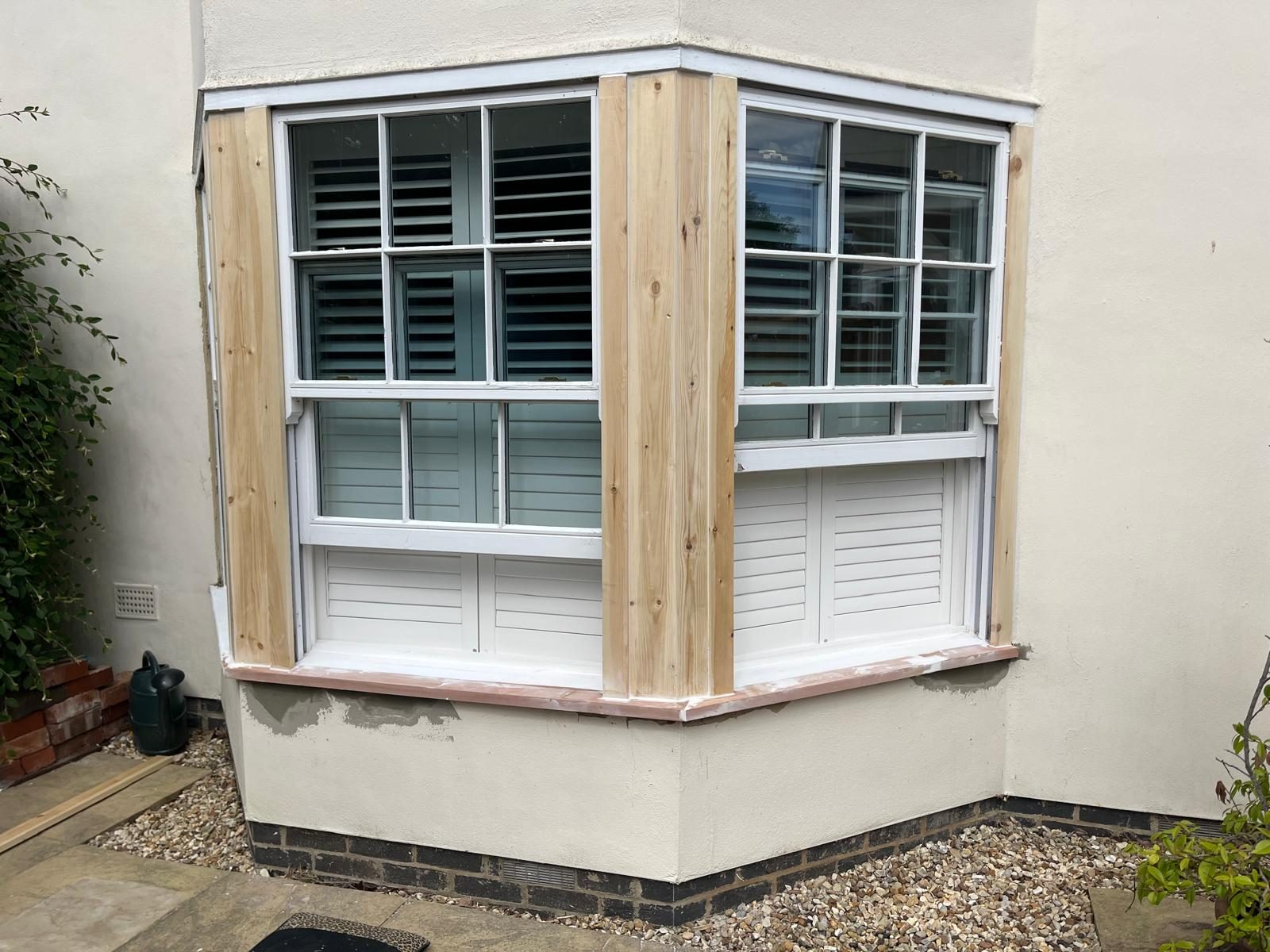 Bay window with rotten timbers cut out and bare replacement sections fitted
