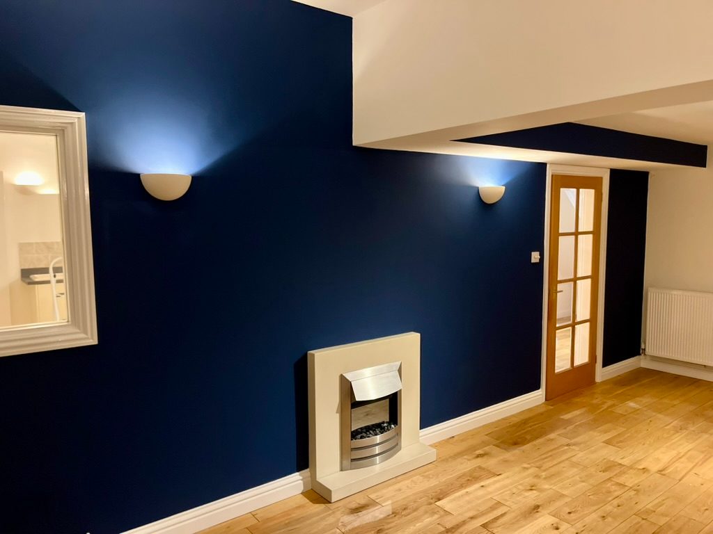 Finished deep navy feature wall with wall lights and fireplace