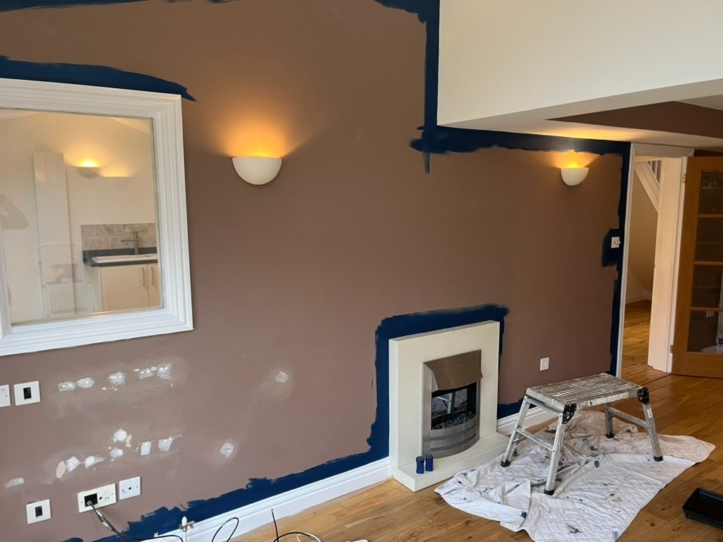 Living room chimney wall part-painted in brown over navy