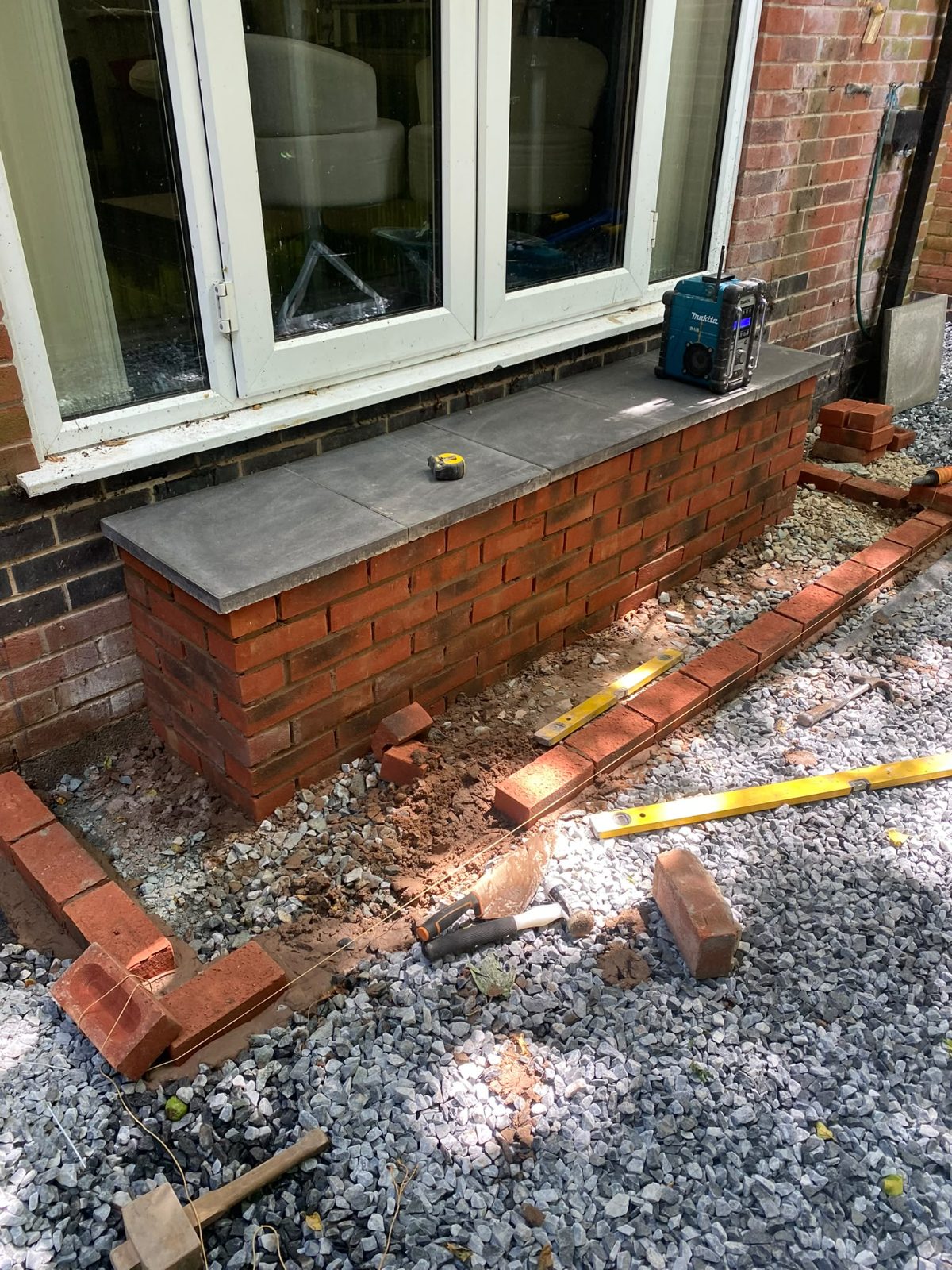 Brick step under construction with slate treads set, line and level in place